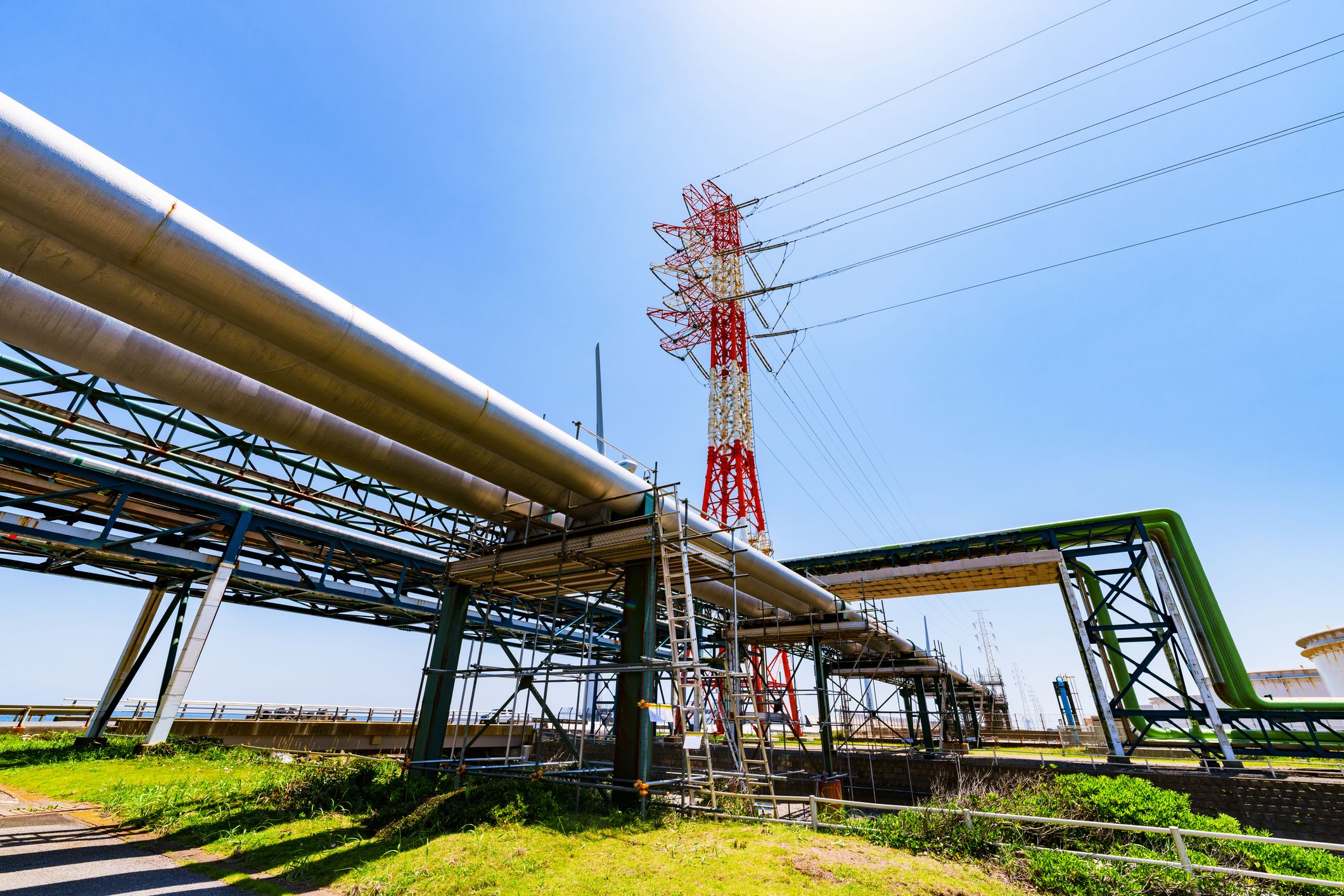 Industrielle Landschaft mit einem Strommast du mehreren Rohrleitungen