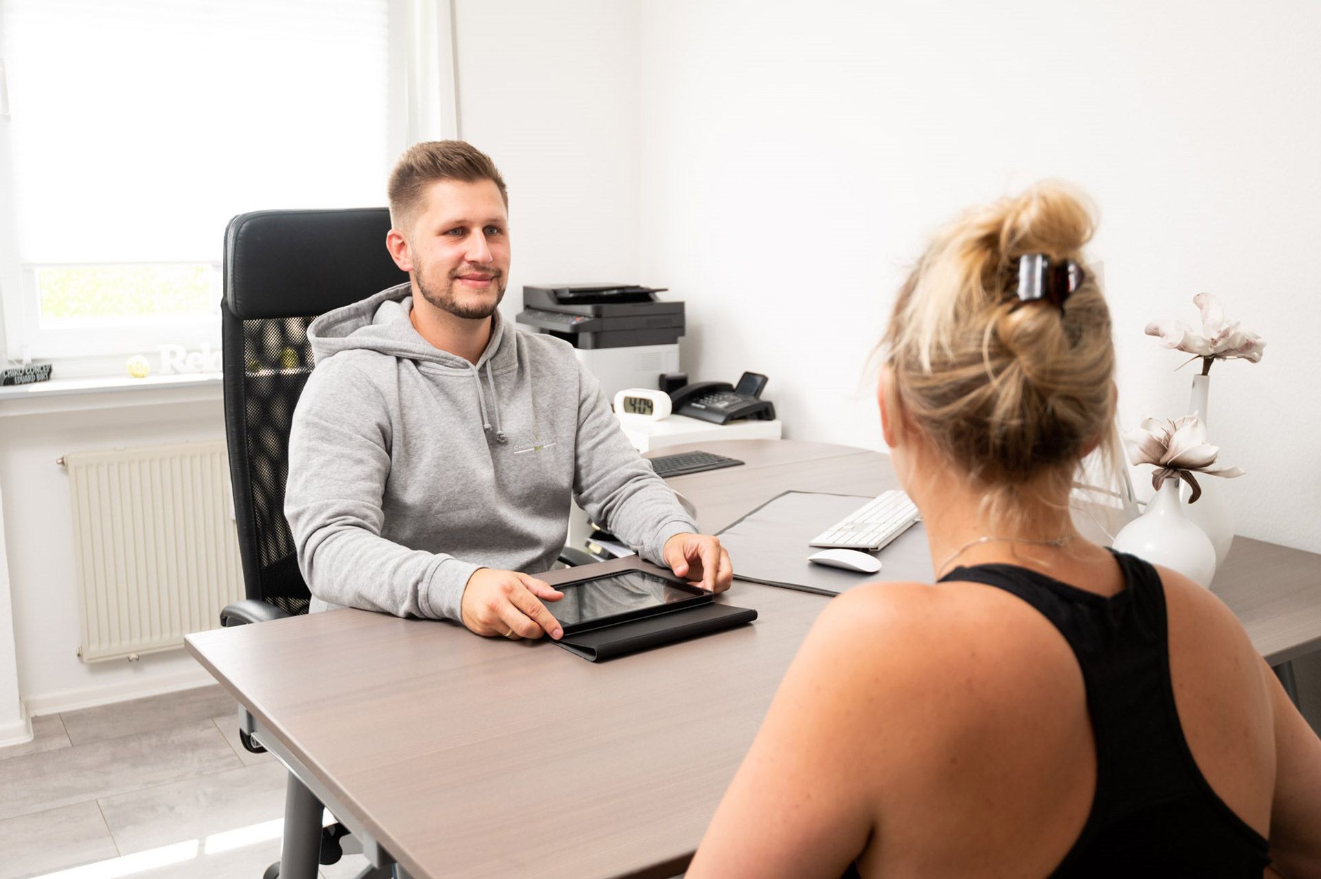 Zwei Menschen, die am Schreibtisch im Büro sitzen