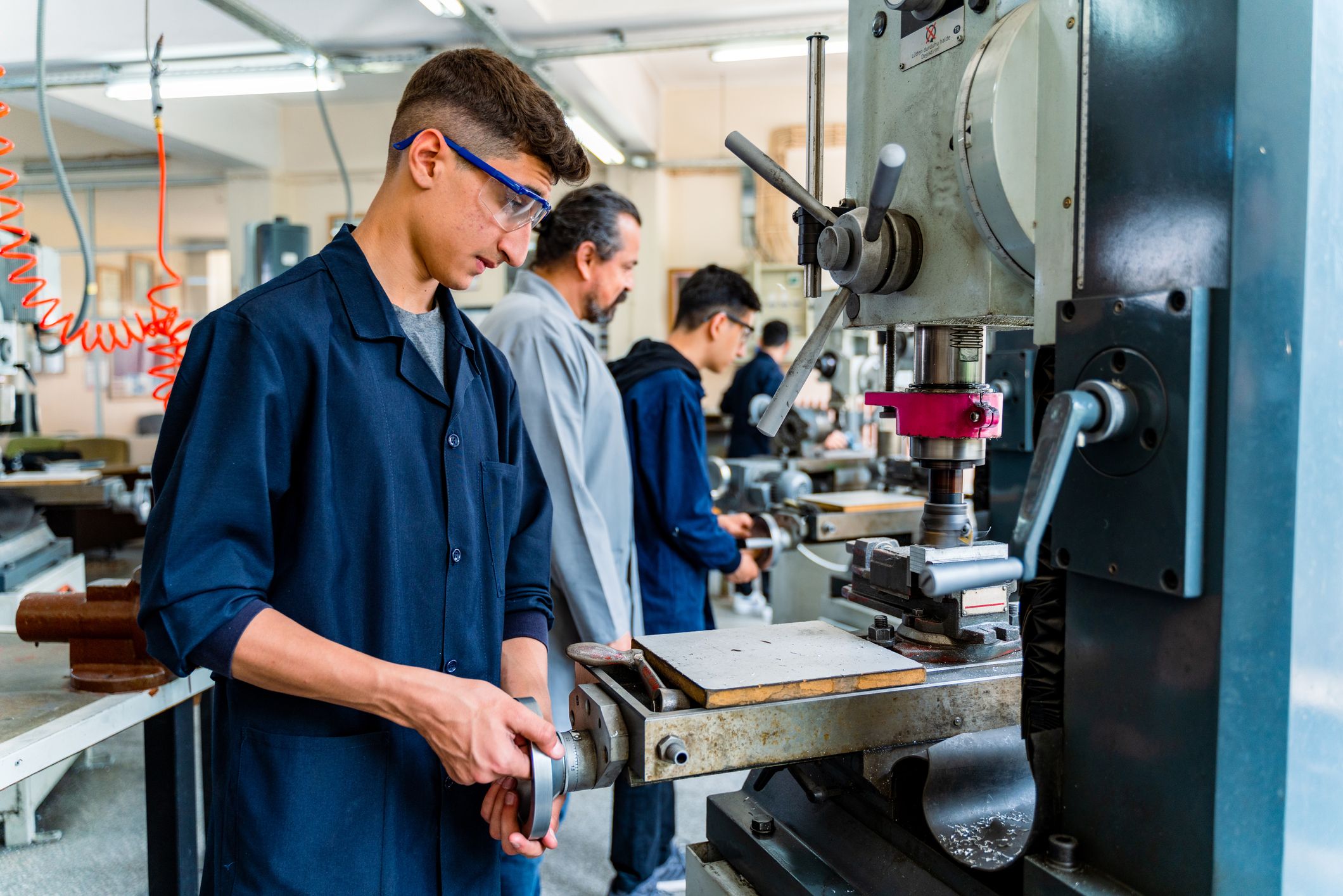 Junger Arbeiter an einer Maschine